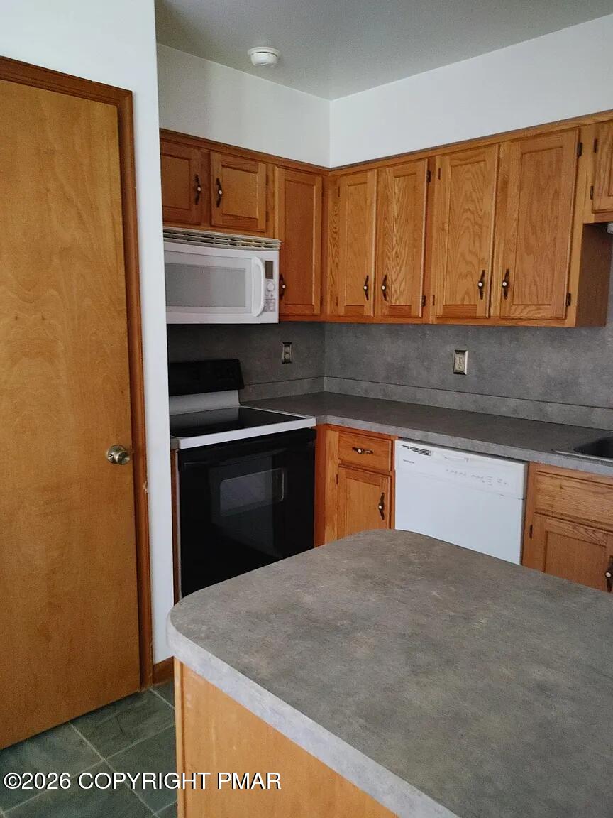 165 Old Stagecoach Road, Unit 3 Gilbert, PA 18331 - Photo 15 of 20 a kitchen with stainless steel appliances granite countertop a stove and a sink