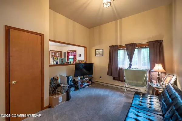 a living room with furniture a window and a flat screen tv