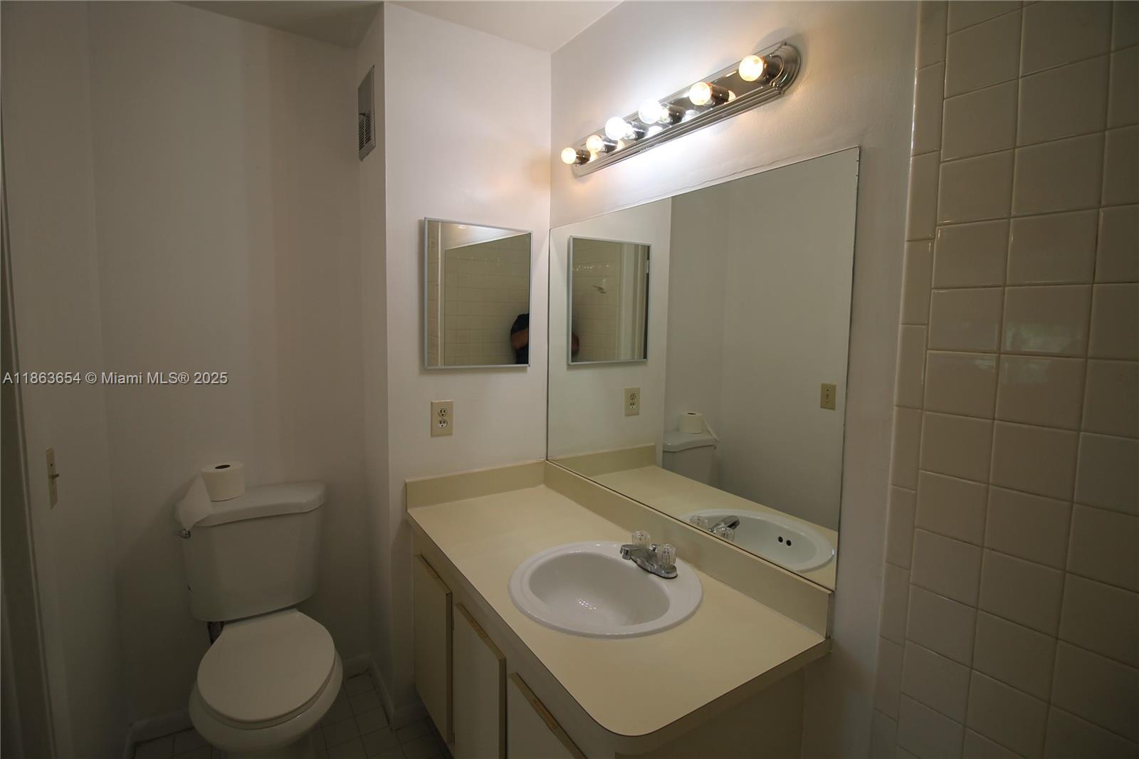 721 Northwest 103rd Terrace, Unit 202 Pembroke Pines, FL 33026 - Photo 14 of 24 a bathroom with a sink toilet and mirror