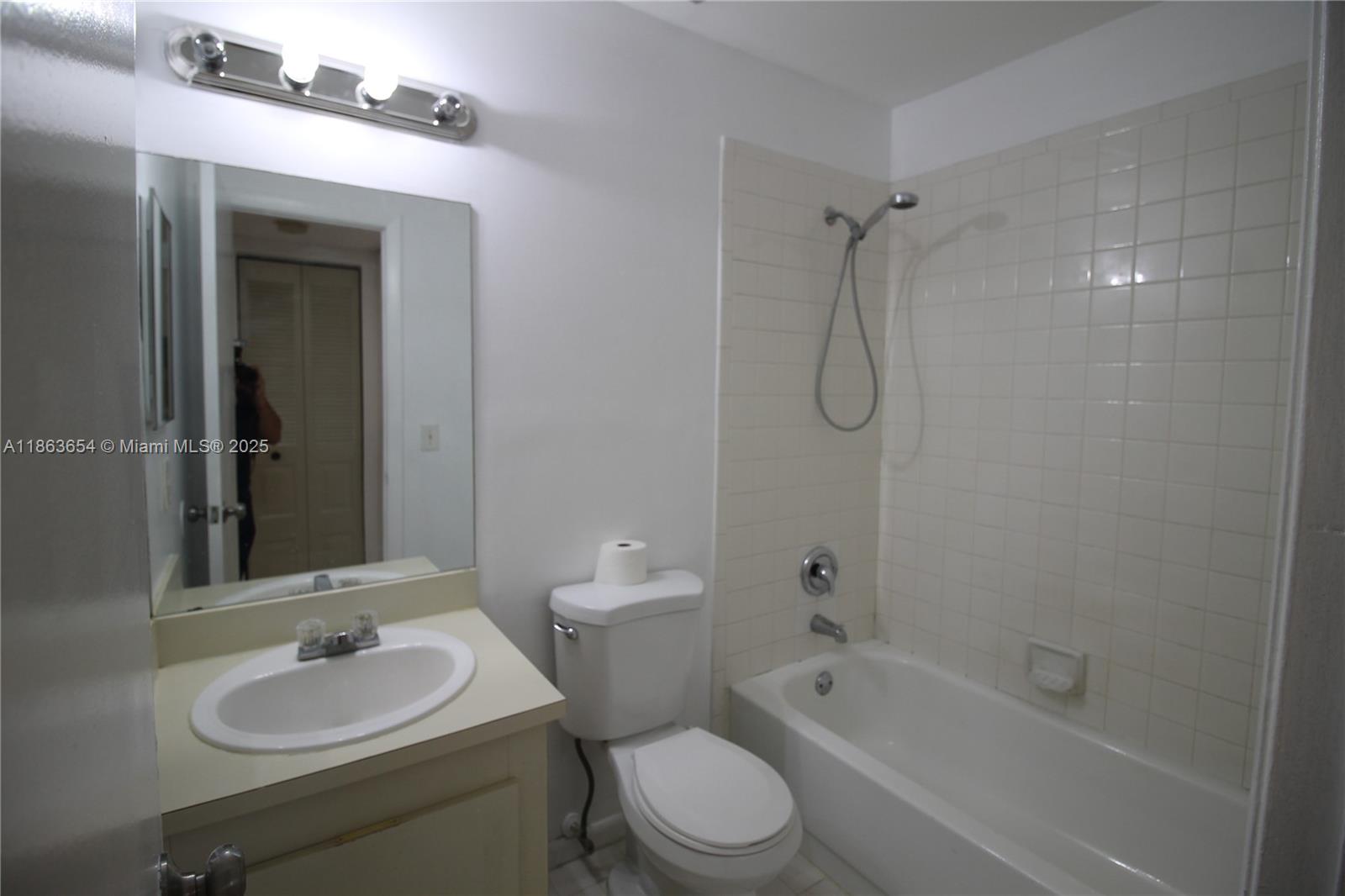 721 Northwest 103rd Terrace, Unit 202 Pembroke Pines, FL 33026 - Photo 17 of 24 a bathroom with a granite countertop sink toilet a shower and a mirror