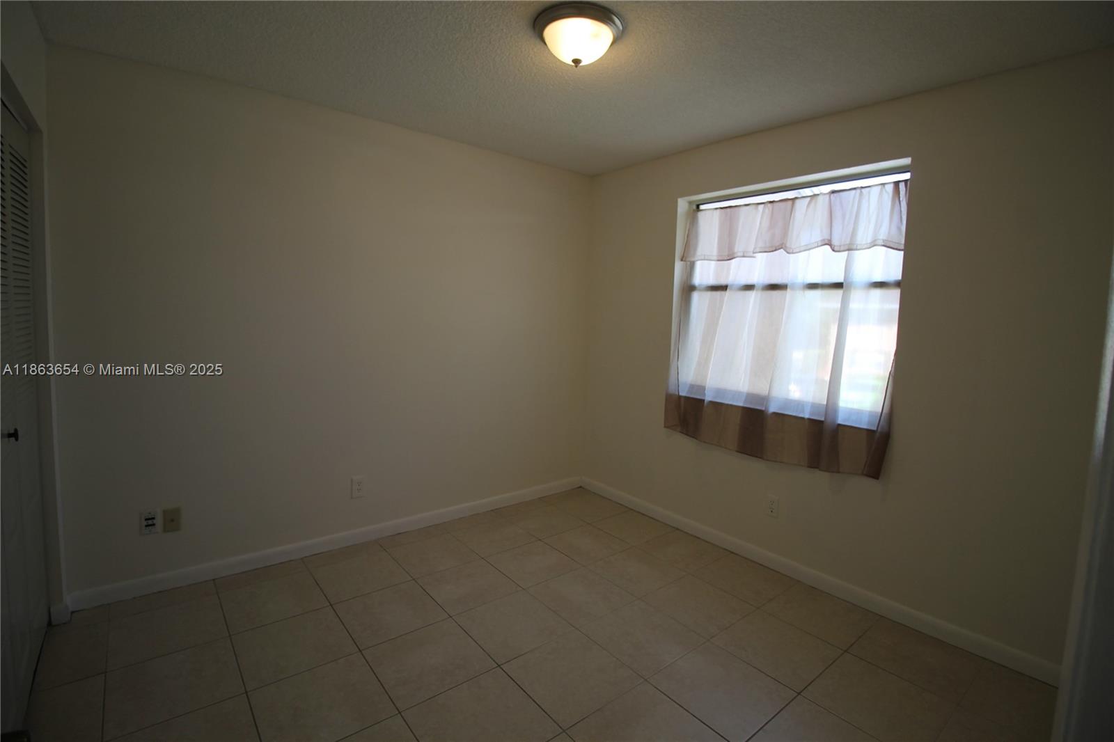721 Northwest 103rd Terrace, Unit 202 Pembroke Pines, FL 33026 - Photo 19 of 24 an empty room with a window