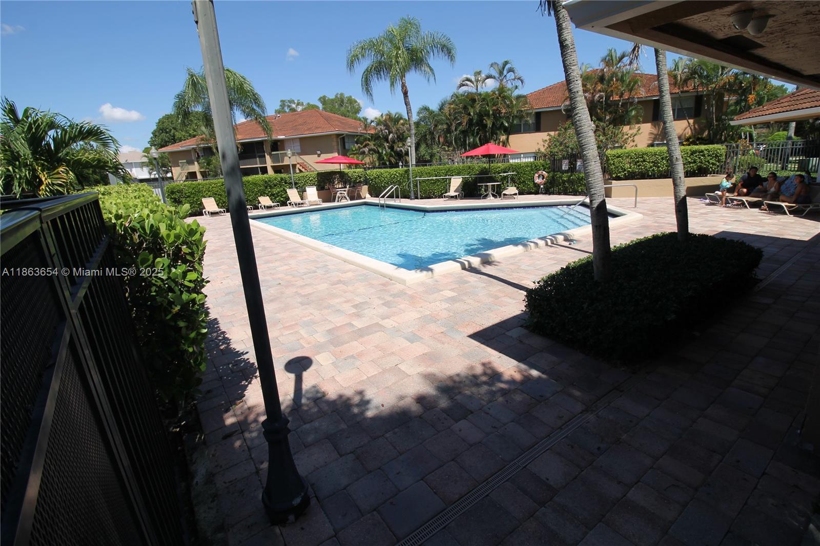 721 Northwest 103rd Terrace, Unit 202 Pembroke Pines, FL 33026 - Photo 21 of 24 a view of a swimming pool with a yard and potted plants