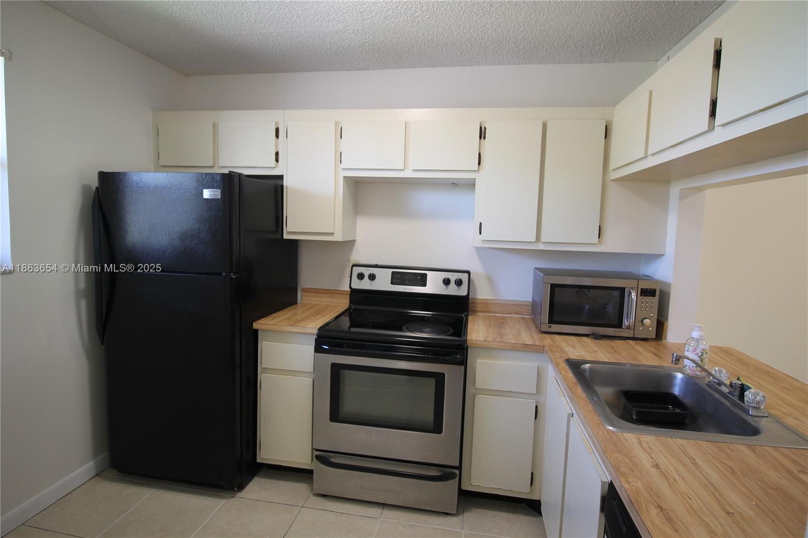721 Northwest 103rd Terrace, Unit 202 Pembroke Pines, FL 33026 - Photo 4 of 24 a kitchen with a stove and a refrigerator