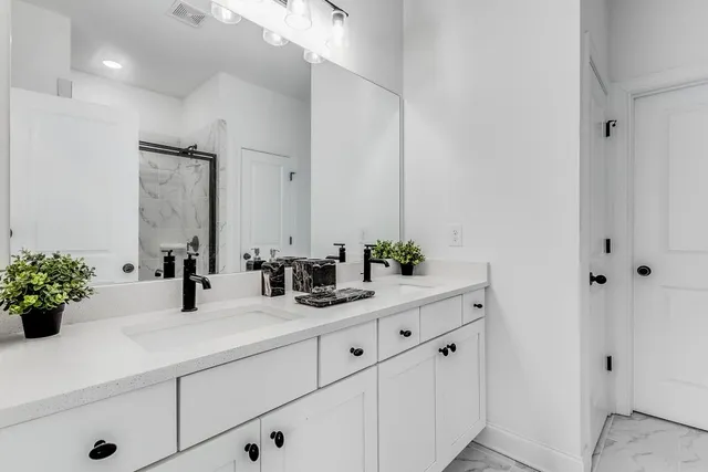 a bathroom with a tub shower vanity and a sink