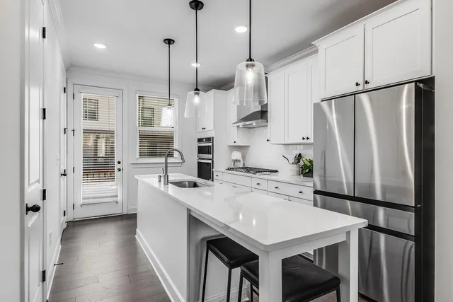a kitchen with stainless steel appliances granite countertop a sink a stove and a refrigerator