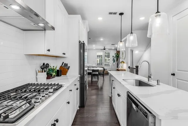 a kitchen with stainless steel appliances a white stove a sink a refrigerator and cabinets