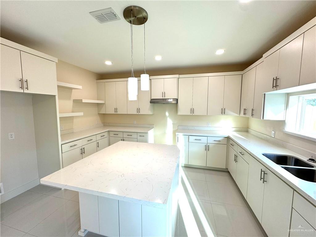 2810 Stablewood Mission, TX 78574 - Photo 6 of 18 a kitchen with a sink a center island stainless steel appliances and cabinets