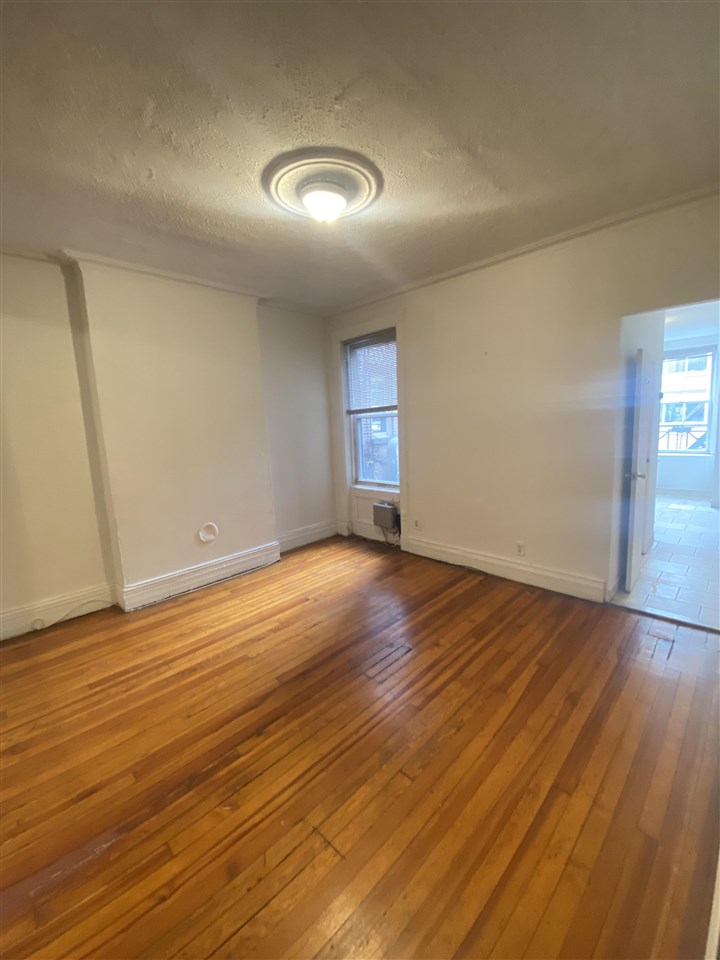 112 14th Street, Unit 7 Hoboken, NJ 07030 - Photo 3 of 8 a view of empty room with wooden floor
