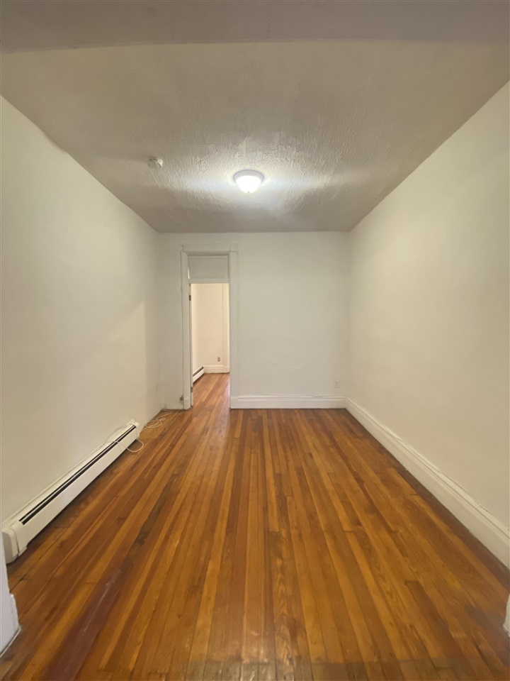112 14th Street, Unit 7 Hoboken, NJ 07030 - Photo 5 of 8 a view of empty room with wooden floor