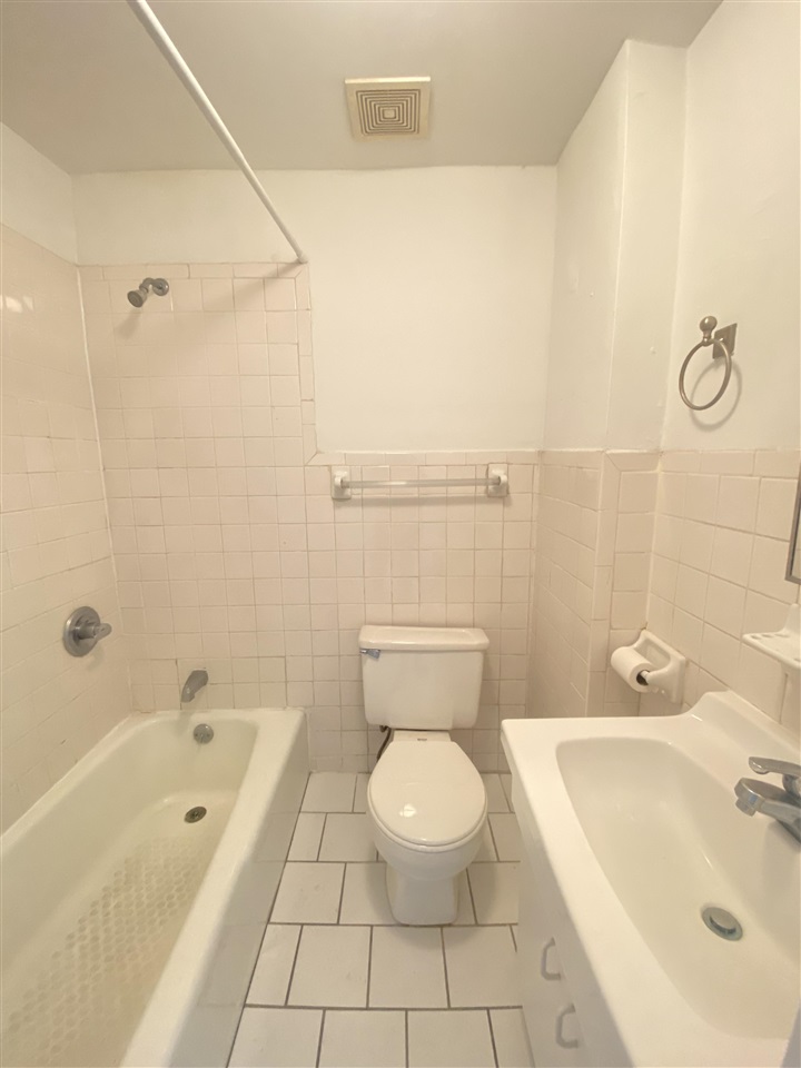 112 14th Street, Unit 7 Hoboken, NJ 07030 - Photo 7 of 8 a bathroom with a bathtub shower sink vanity and toilet