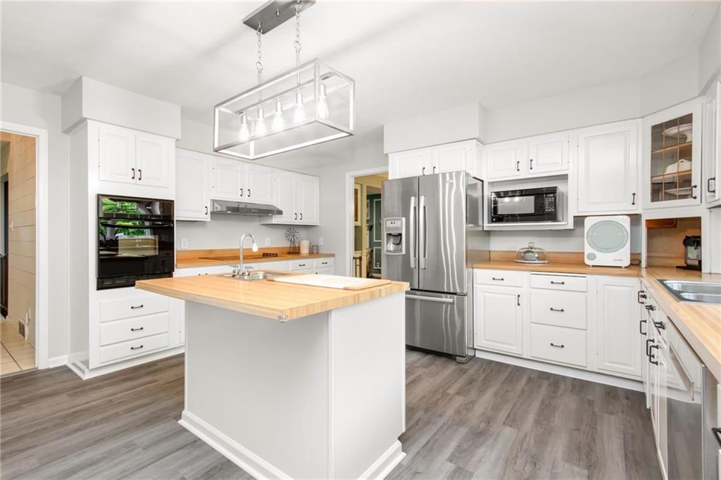 276 Oakville Road Beaver Falls, PA 15010 - Photo 2 of 25 A large eat-in kitchen features an island w/prep sink, luxury vinyl planked flooring, SS appliances & tons of cabinet space.