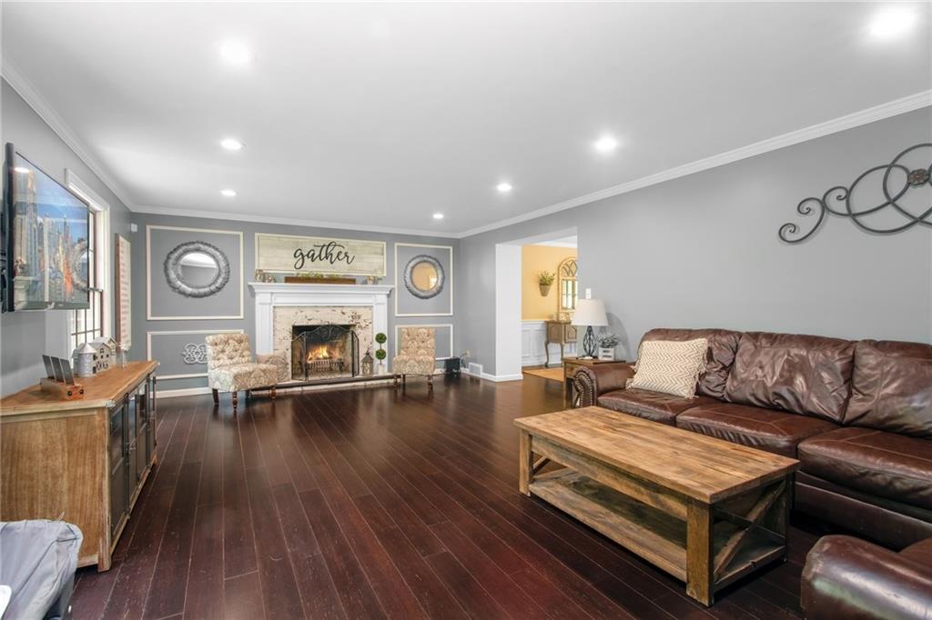 276 Oakville Road Beaver Falls, PA 15010 - Photo 7 of 25 Bamboo floors, recessed lighting, crown molding and a brick fireplace with a German smear finish lends farmhouse sophistication to the living room.