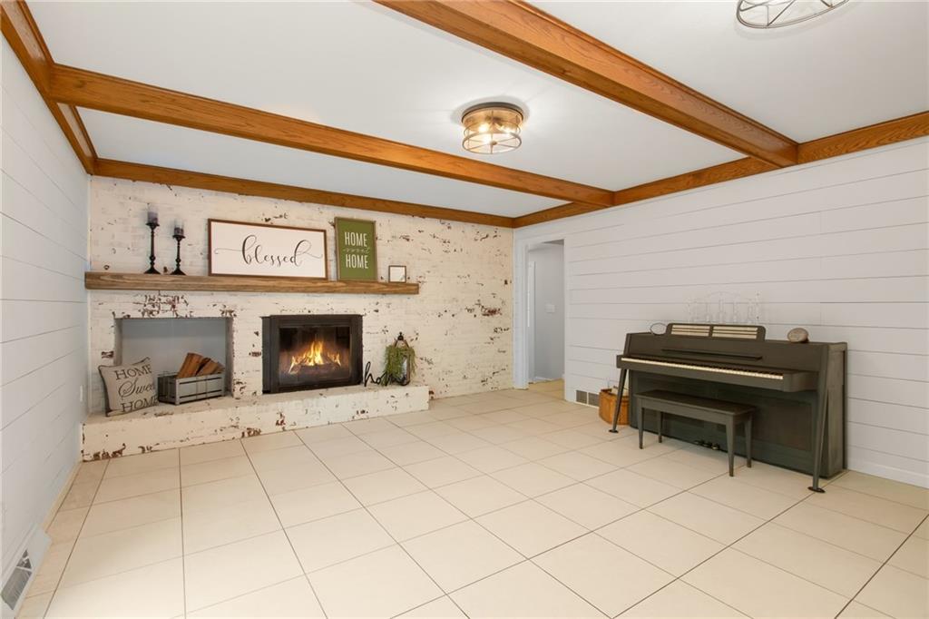 276 Oakville Road Beaver Falls, PA 15010 - Photo 9 of 25 Shiplap walls, brick fireplace with a German smear finish & beamed ceiling give the main floor family room a rustic relaxed vibe.