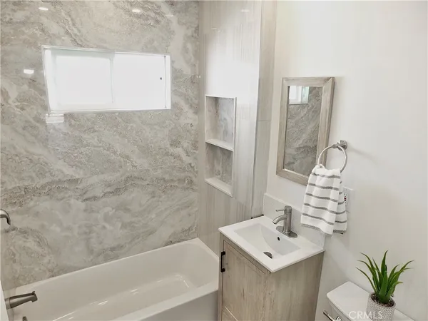 a bathroom with a sink a bathtub and a mirror