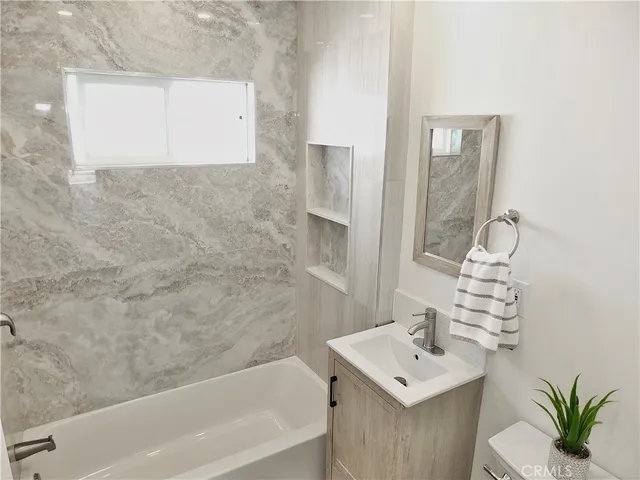 a bathroom with a sink a bathtub and a mirror