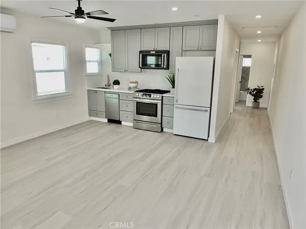 a kitchen with stainless steel appliances a refrigerator sink and microwave