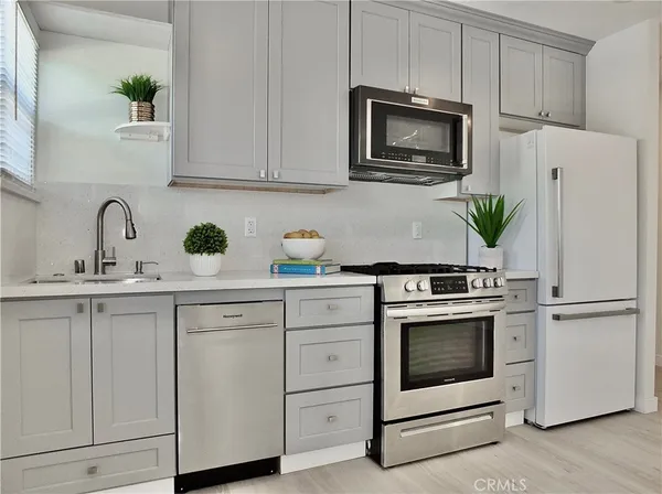 a kitchen with white cabinets stainless steel appliances and sink