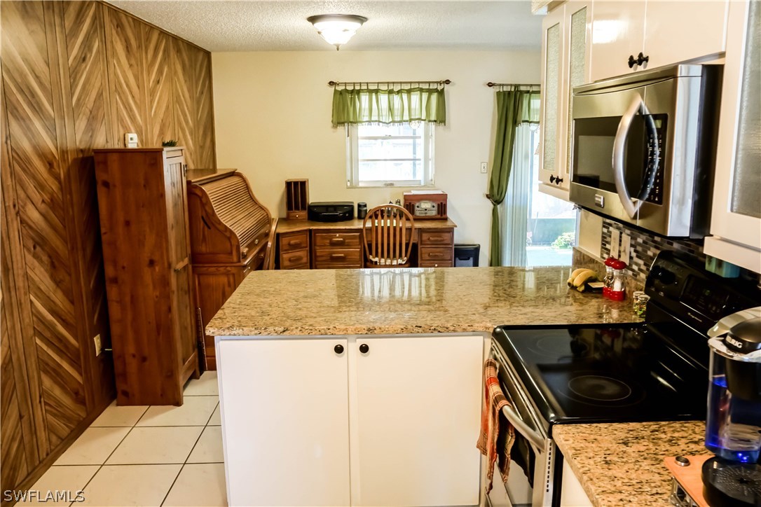 18473 Geranium Road Fort Myers, FL 33967 - Photo 7 of 25 a kitchen with granite countertop a sink a stove and a refrigerator