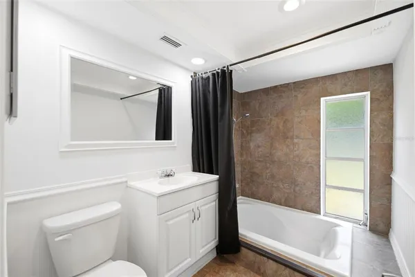 a bathroom with a sink toilet vanity and shower