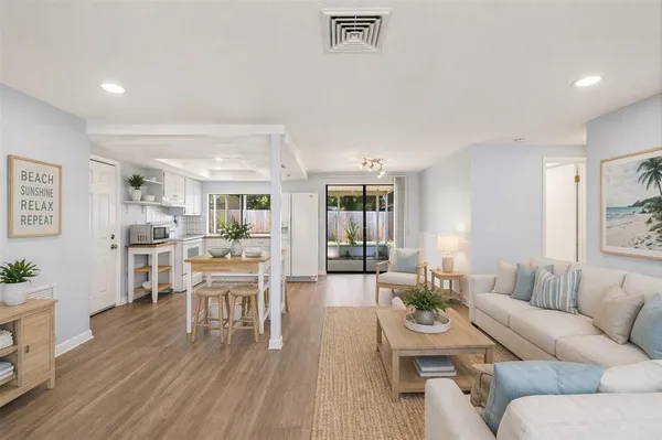 a living room with furniture wooden floor and a large window