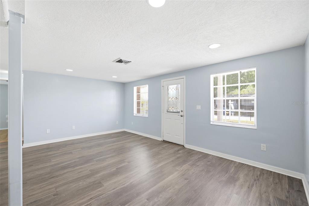 3303 Williamsburg Loop Holiday, FL 34691 - Photo 7 of 31 a view of an empty room with wooden floor and a window