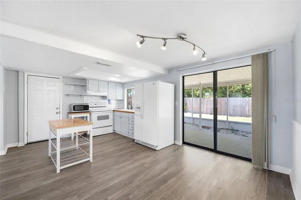 a kitchen with white cabinets and wooden floor