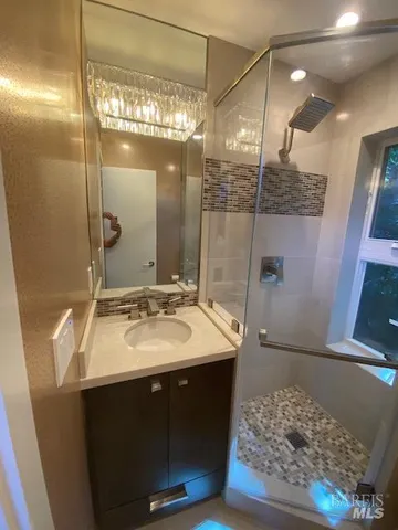 a bathroom with a granite countertop sink toilet and shower