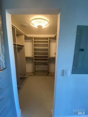 a view of an empty room with wooden floor and windows