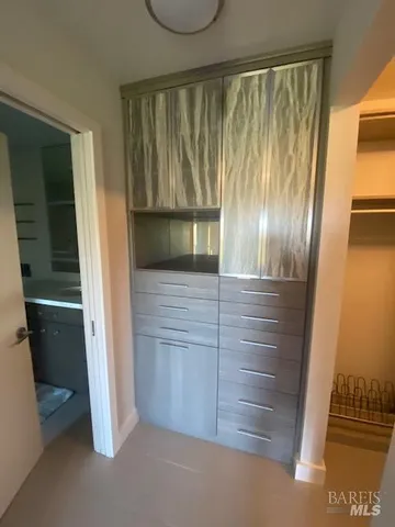 a view of an empty room with wooden floor and windows