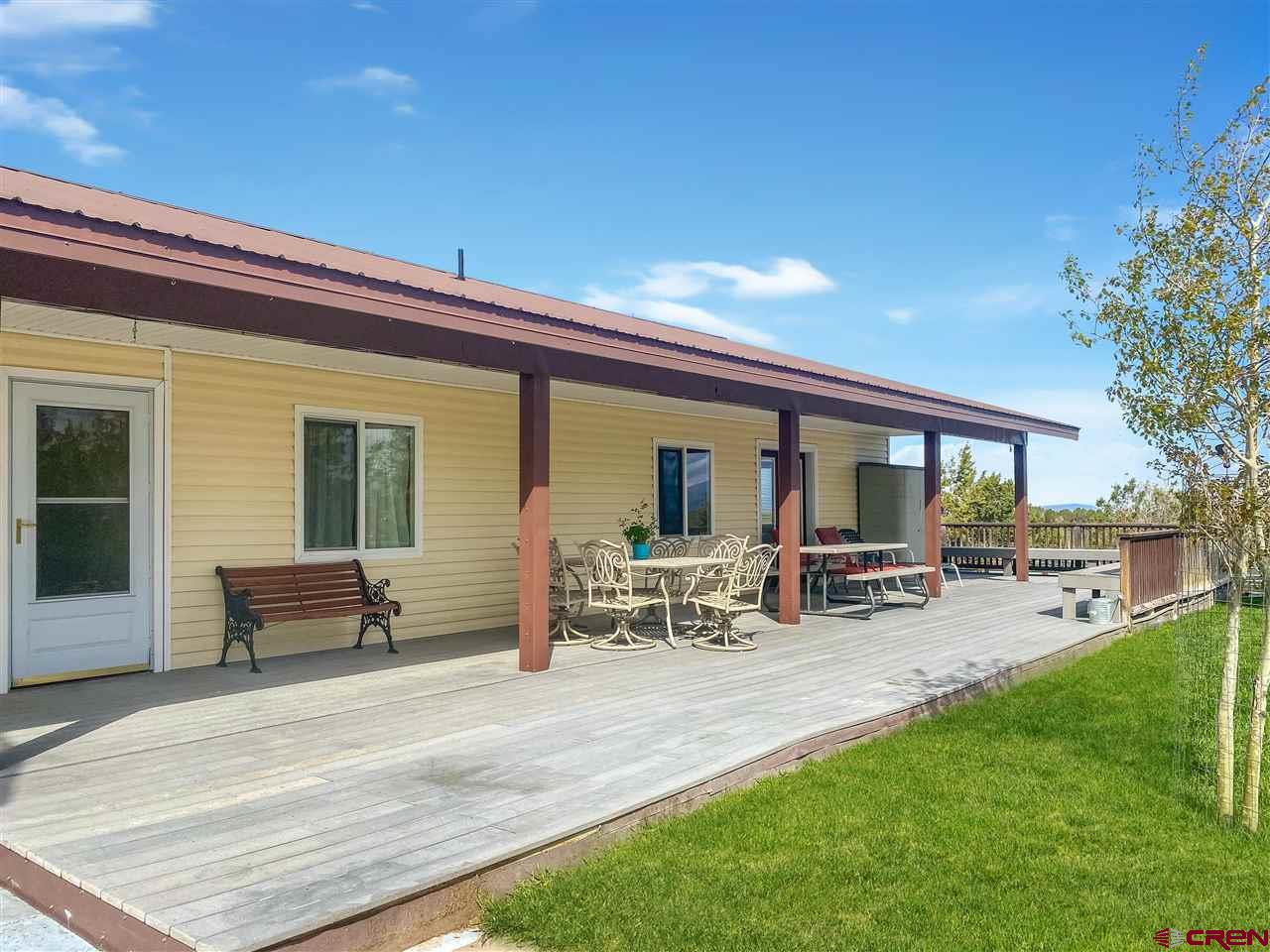 34354 3575th Road Redvale, CO 81431 - Photo 19 of 30 a view of a house with patio and a garden