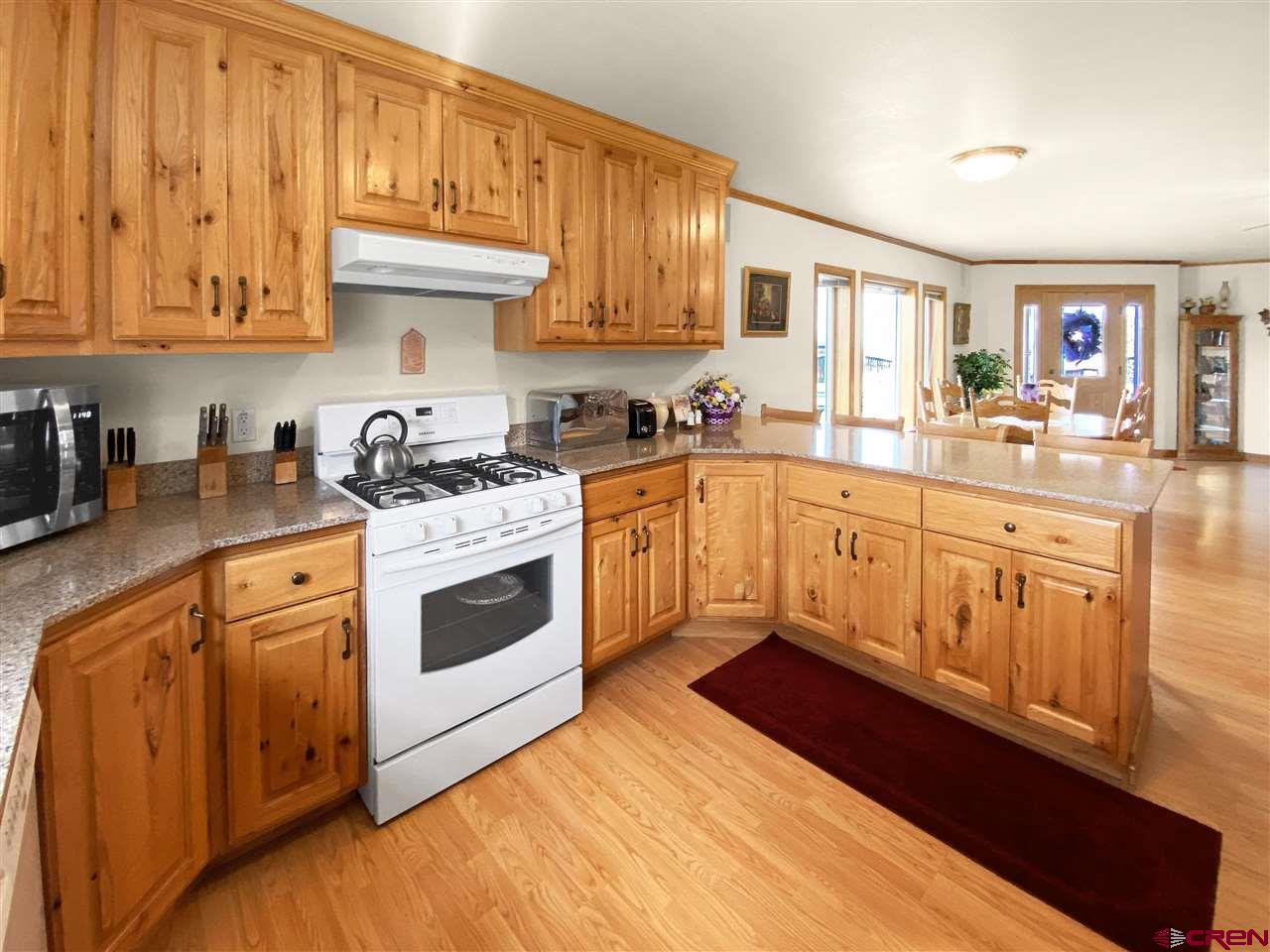 34354 3575th Road Redvale, CO 81431 - Photo 7 of 30 a kitchen with stainless steel appliances granite countertop a stove a sink dishwasher and a refrigerator