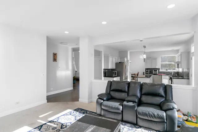 a living room with furniture and a view of kitchen