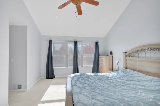 a bedroom with a large bed and a chandelier