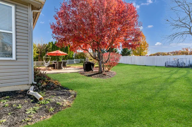 a view of a patio with a table and chairs under an umbrella with a fire pit