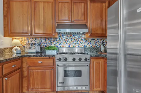 a kitchen with granite countertop cabinets stainless steel appliances and wooden cabinets