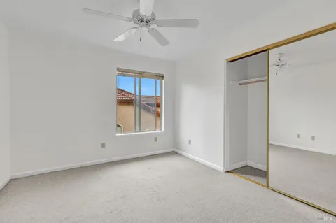 an empty room with a ceiling fan and a window