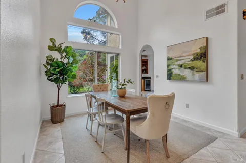 a view of a dining room with furniture a potted plant and a chandelier