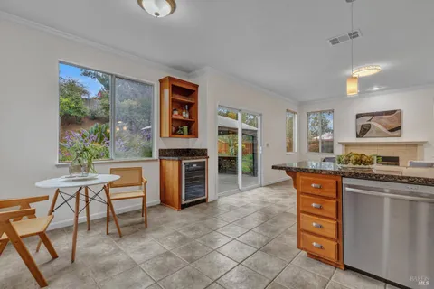 a large kitchen with stainless steel appliances granite countertop a stove a sink a dining table and chair