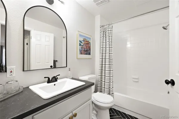 a bathroom with a sink toilet a mirror and shower