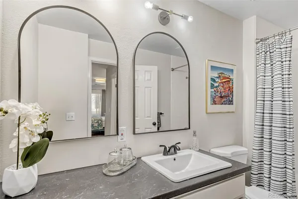a bathroom with a granite countertop sink a mirror and vanity
