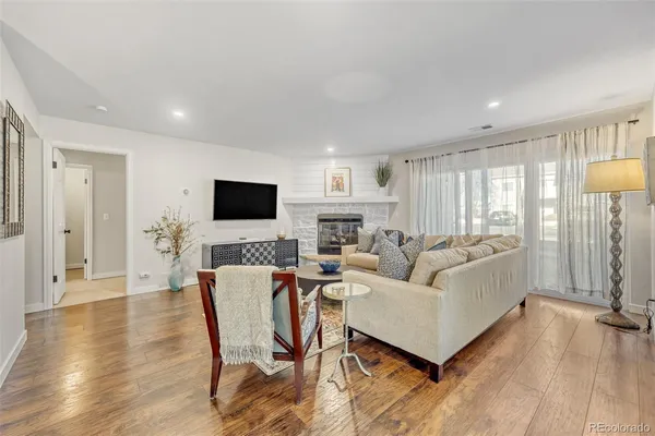 a living room with furniture a flat screen tv and a fireplace