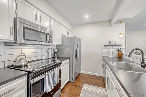 a kitchen with stainless steel appliances granite countertop a sink stove and refrigerator