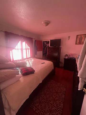 a bedroom with a bed and wooden floor