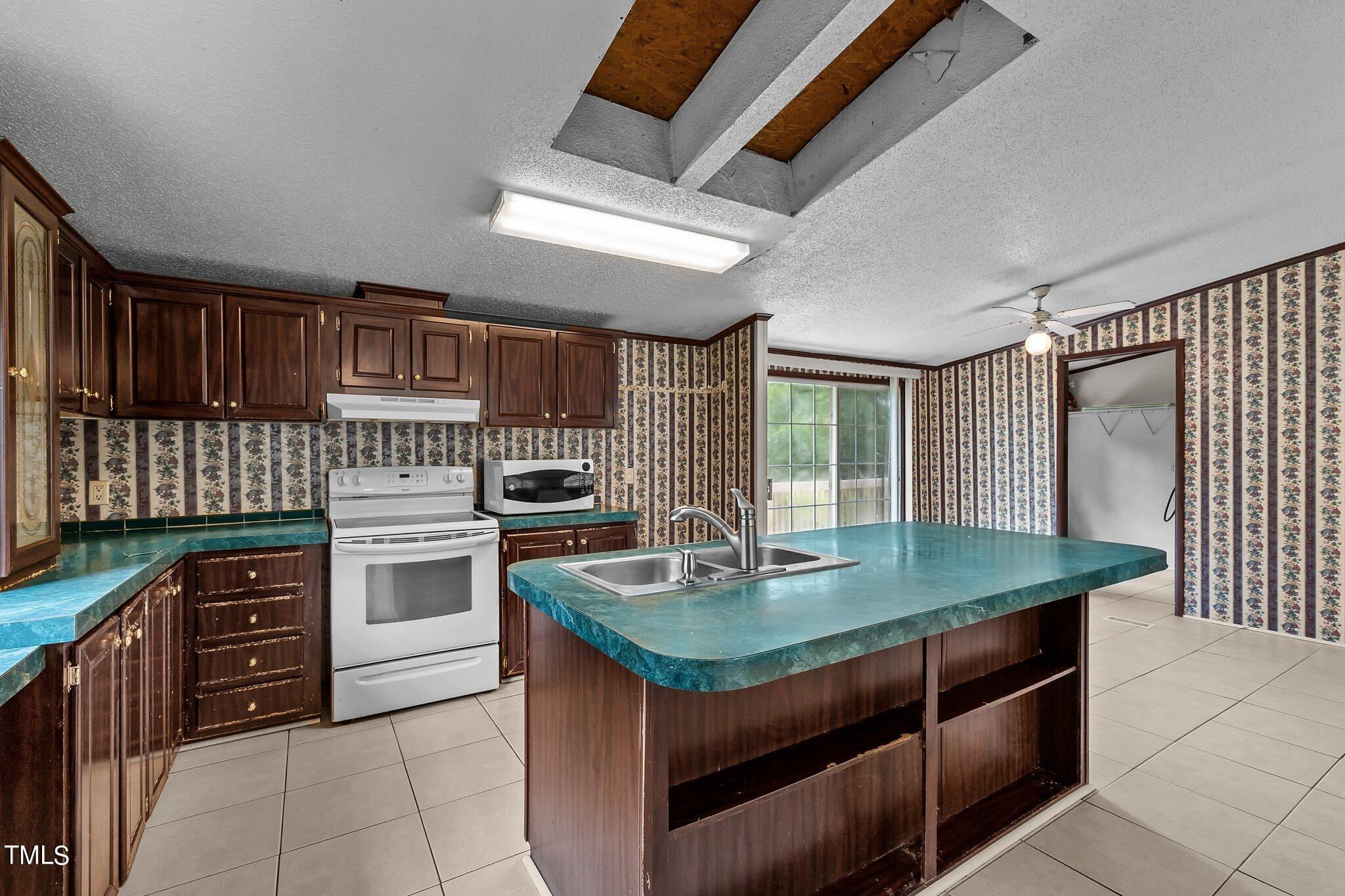 5612 Zacks Mill Road Angier, NC 27501 - Photo 11 of 42 a kitchen with a stove a sink and cabinets
