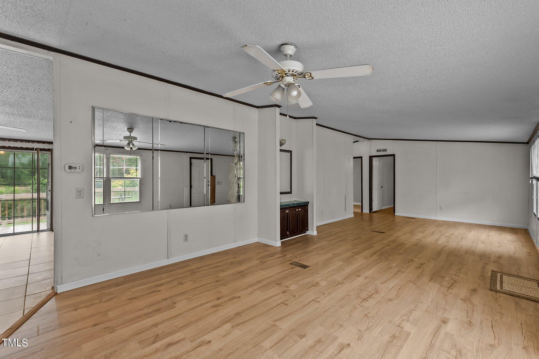 5612 Zacks Mill Road Angier, NC 27501 - Photo 15 of 42 a view of empty room with wooden floor and fan
