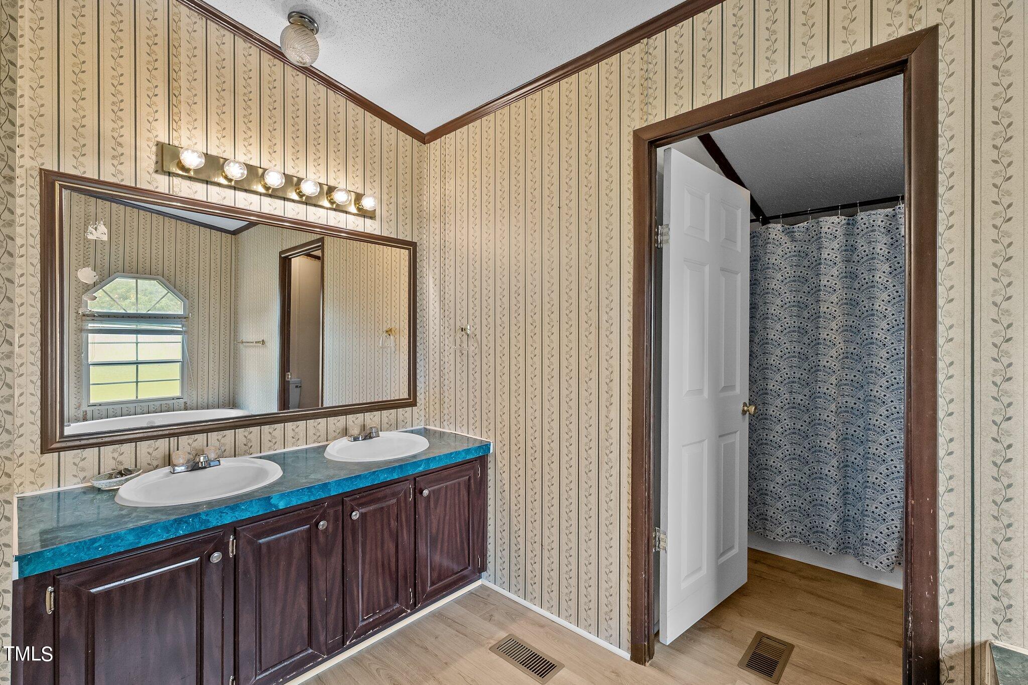 5612 Zacks Mill Road Angier, NC 27501 - Photo 21 of 42 a bathroom with a sink a mirror and a shower