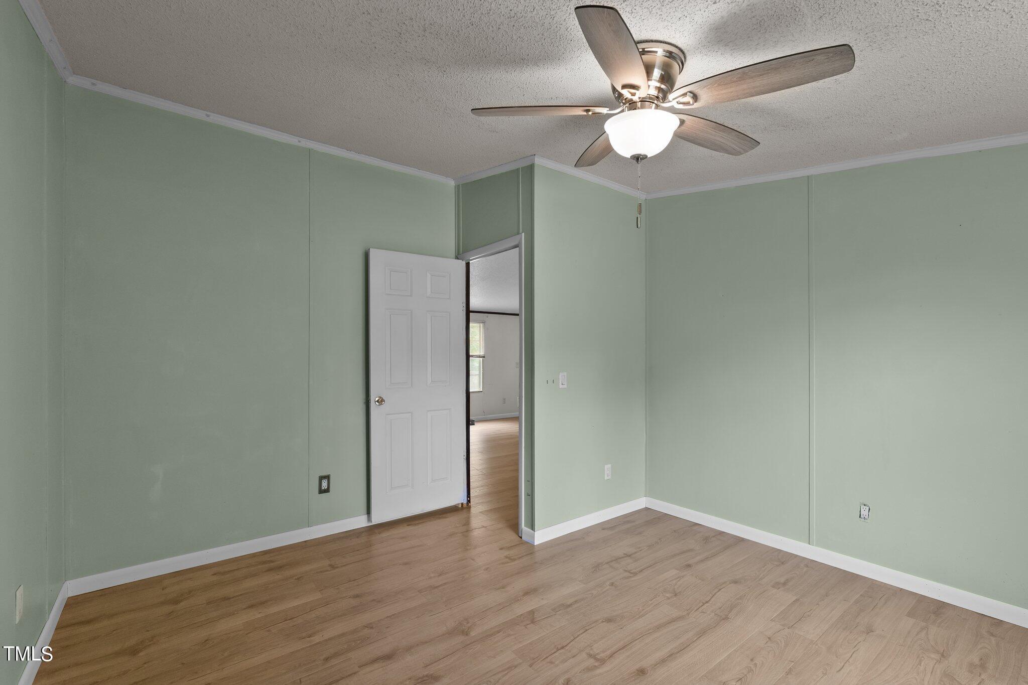 5612 Zacks Mill Road Angier, NC 27501 - Photo 22 of 42 an empty room with wooden floor and ceiling fan