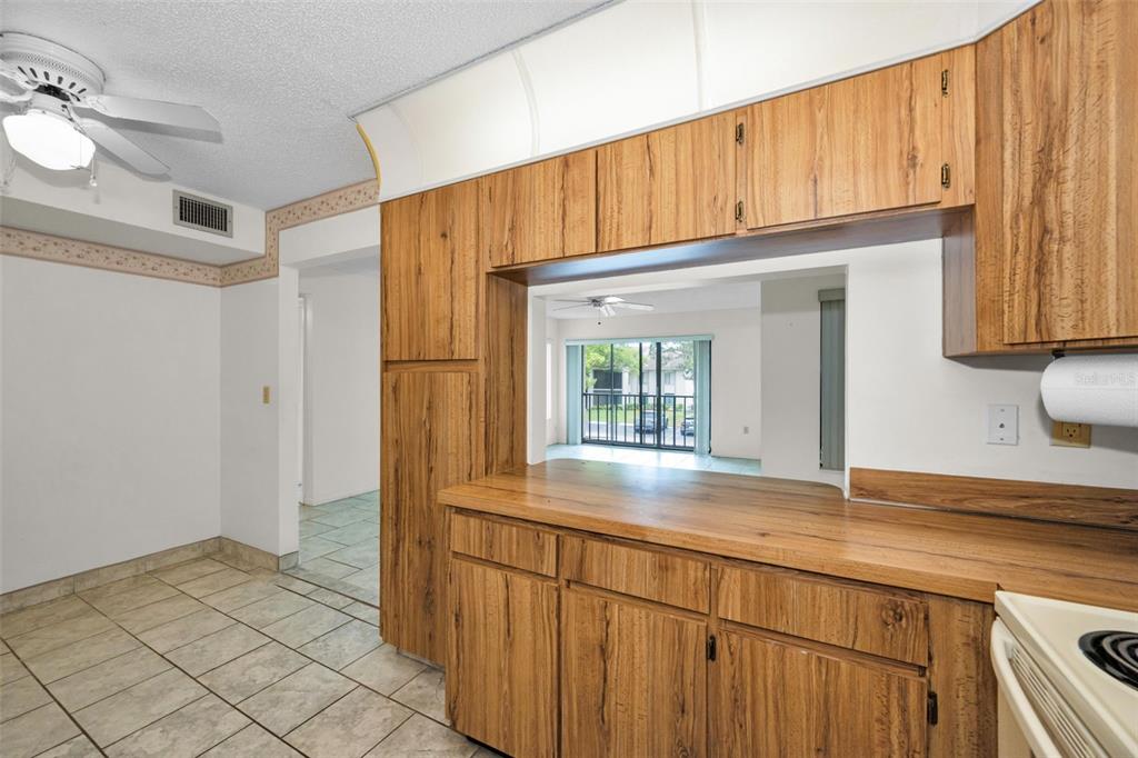 2687 Pine Ridge Way South, Unit B2 Palm Harbor, FL 34684 - Photo 13 of 68 a kitchen with granite countertop white cabinets and a refrigerator