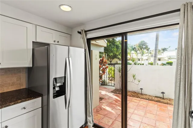 a kitchen with granite countertop a refrigerator and a large window