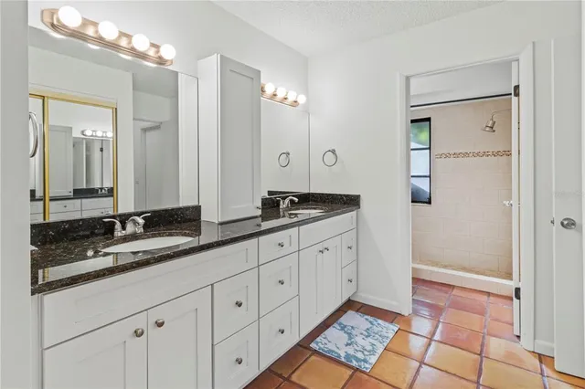 a spacious bathroom with double sink and a mirror
